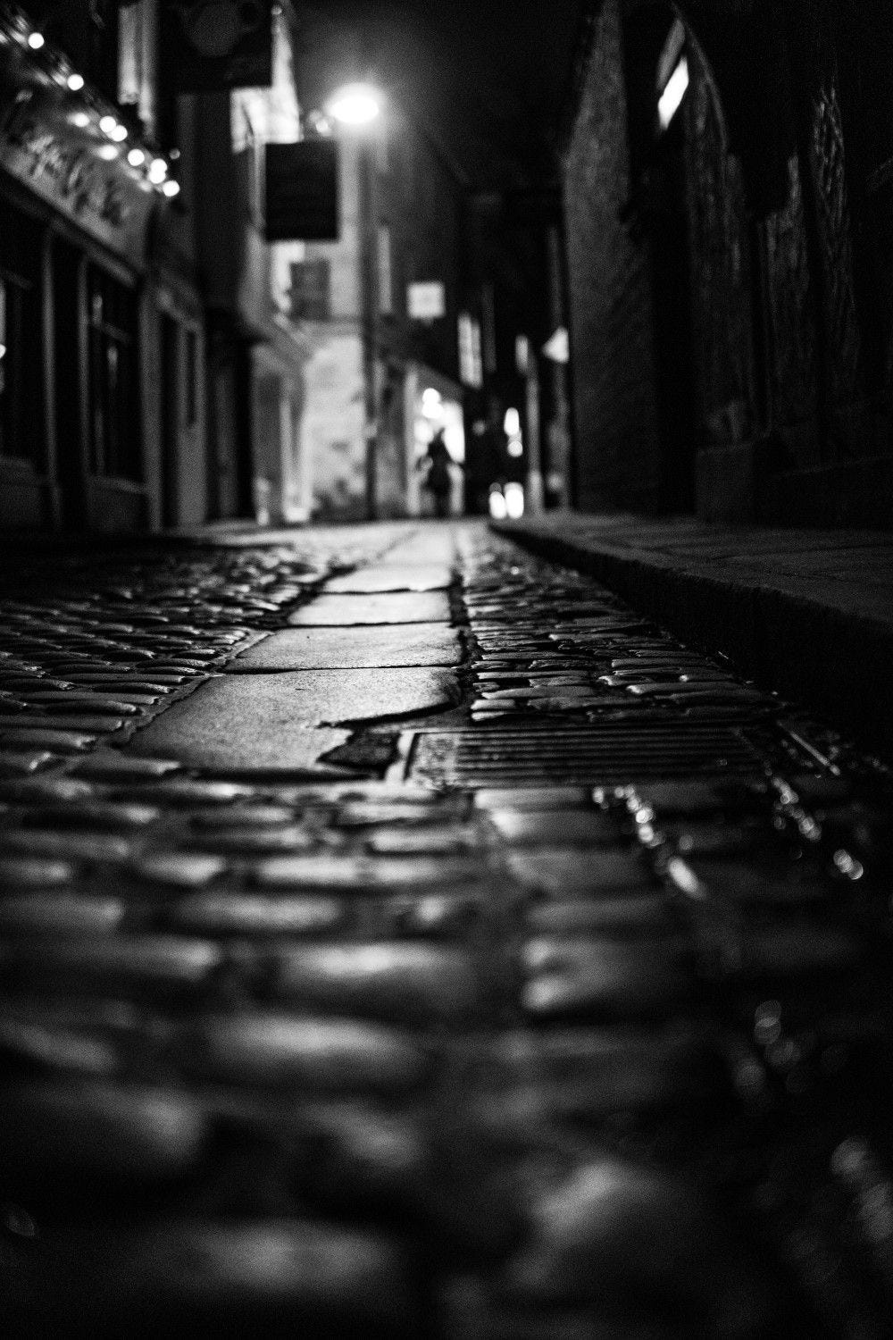 Calle a oscuras de noche con luces de farolas encendidas acechando el peligro Calle a oscuras de noche con luces de farolas encendidas acechando el peligro