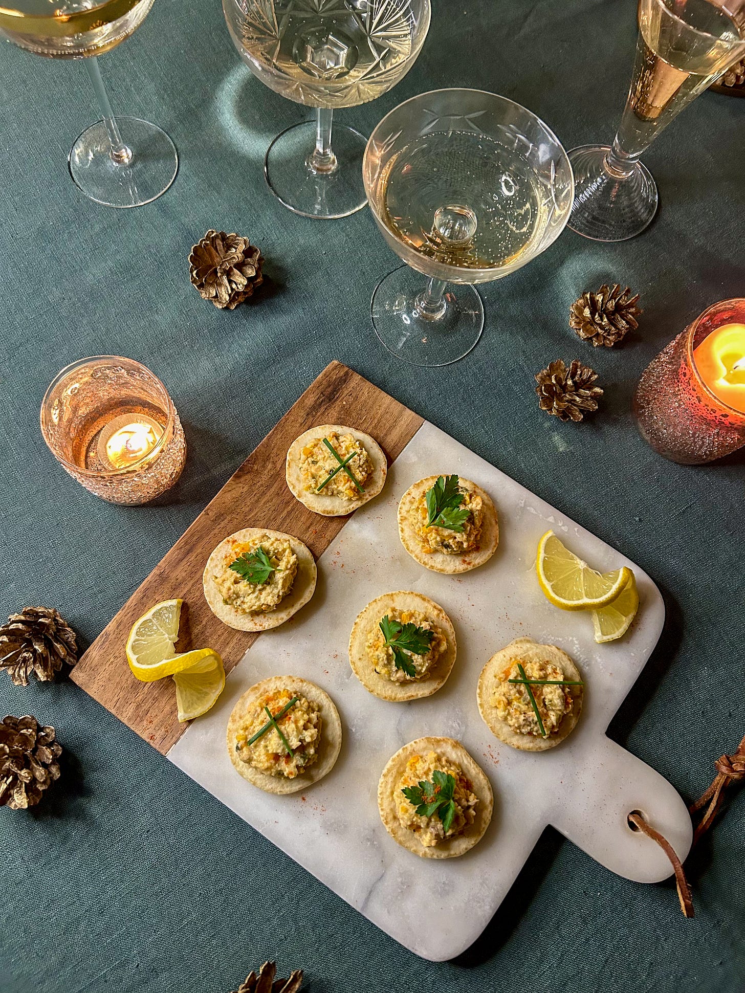 Trays filled with Champagne, hors d'oeuvres and appetizers, and a place setting featuring citrus fruits for a holiday dinner Trays filled with Champagne, hors d'oeuvres and appetizers, and a place setting featuring citrus fruits for a holiday dinner