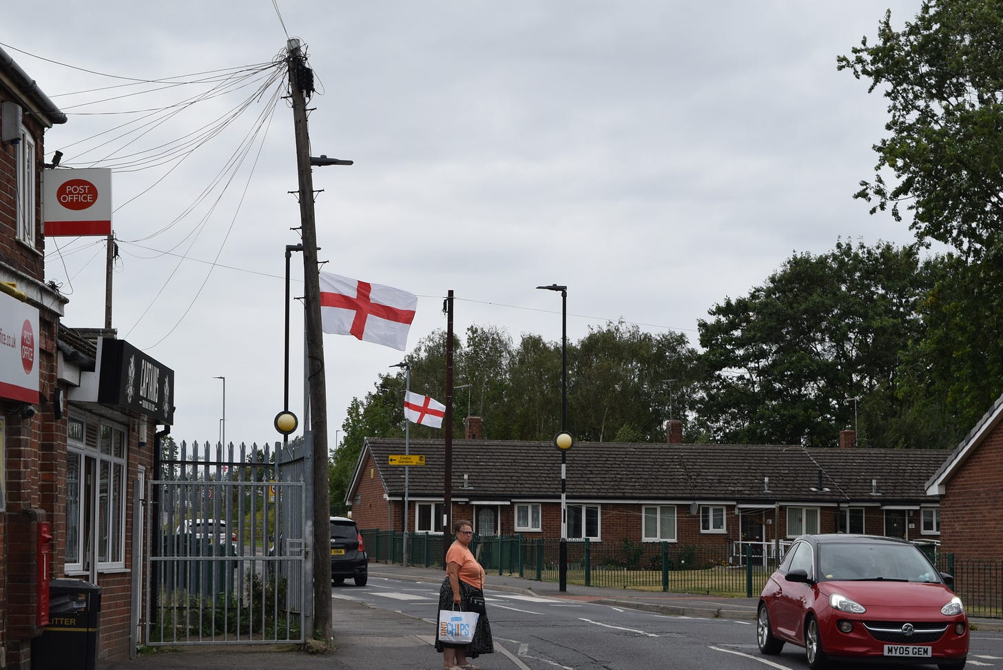 Flags hanging from lampposts on a quiet street
