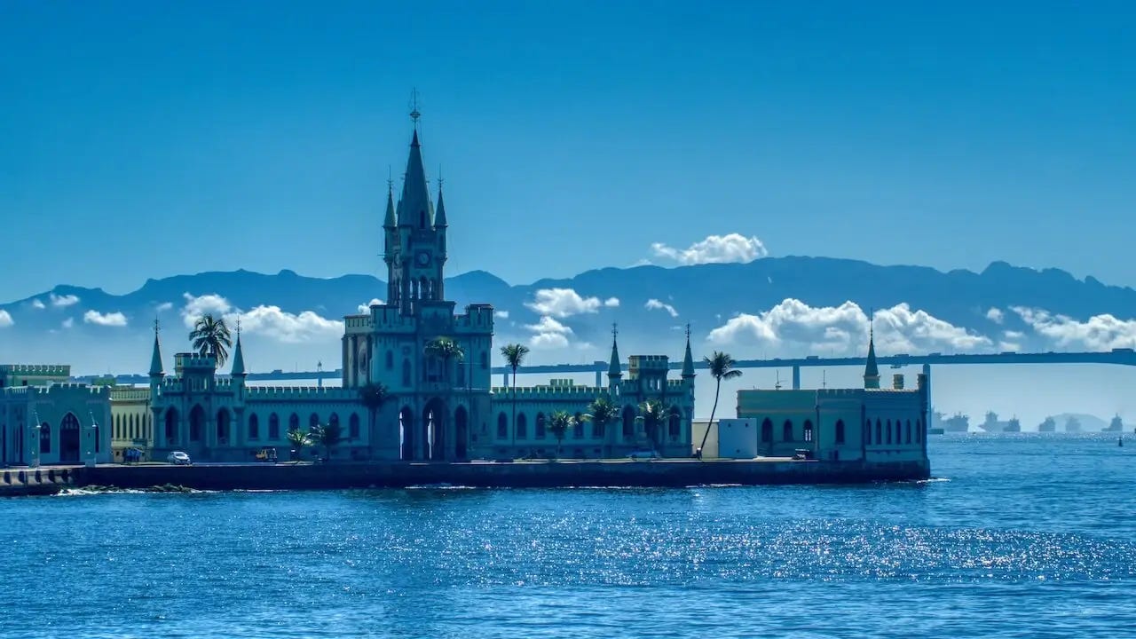 A mansion with arched windows with mountains and low cloud in the background