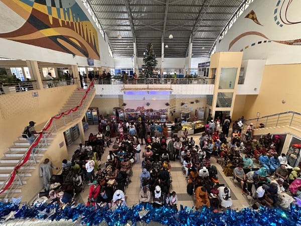 People sitting in chairs in a large room. The view is from above.