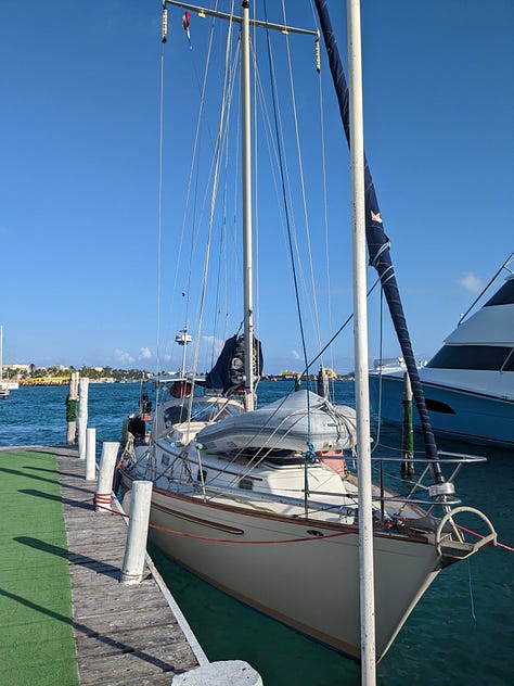 Me on my penultimate morning watch, Isla Mujeres on the horizon, and our boat tied up for entry proceedings.