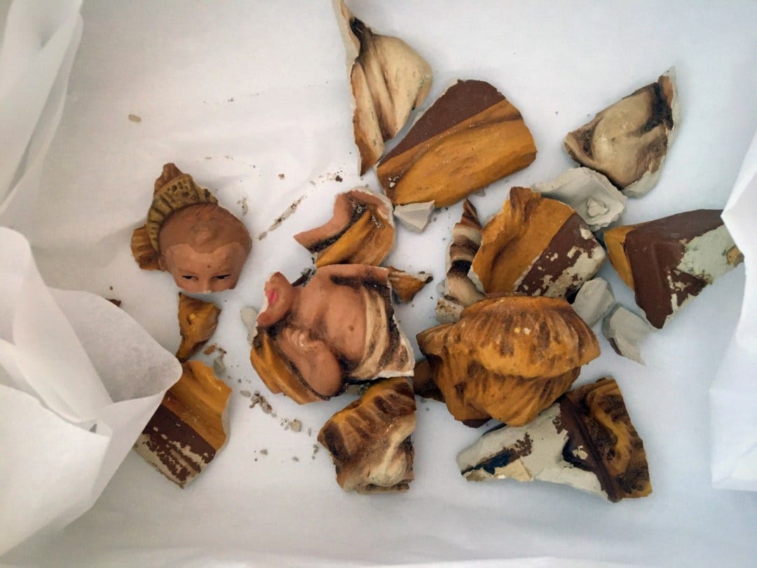 assembly Broken pieces of Jesus figurine on tissue paper