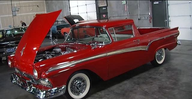 Shiny red 1957 Ford Ranchero with open hood, view from left front