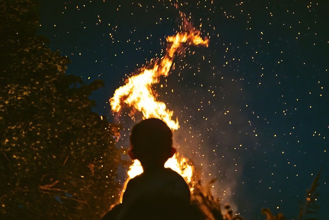 silhouette of people looking on fire under starry night silhouette of people looking on fire under starry night