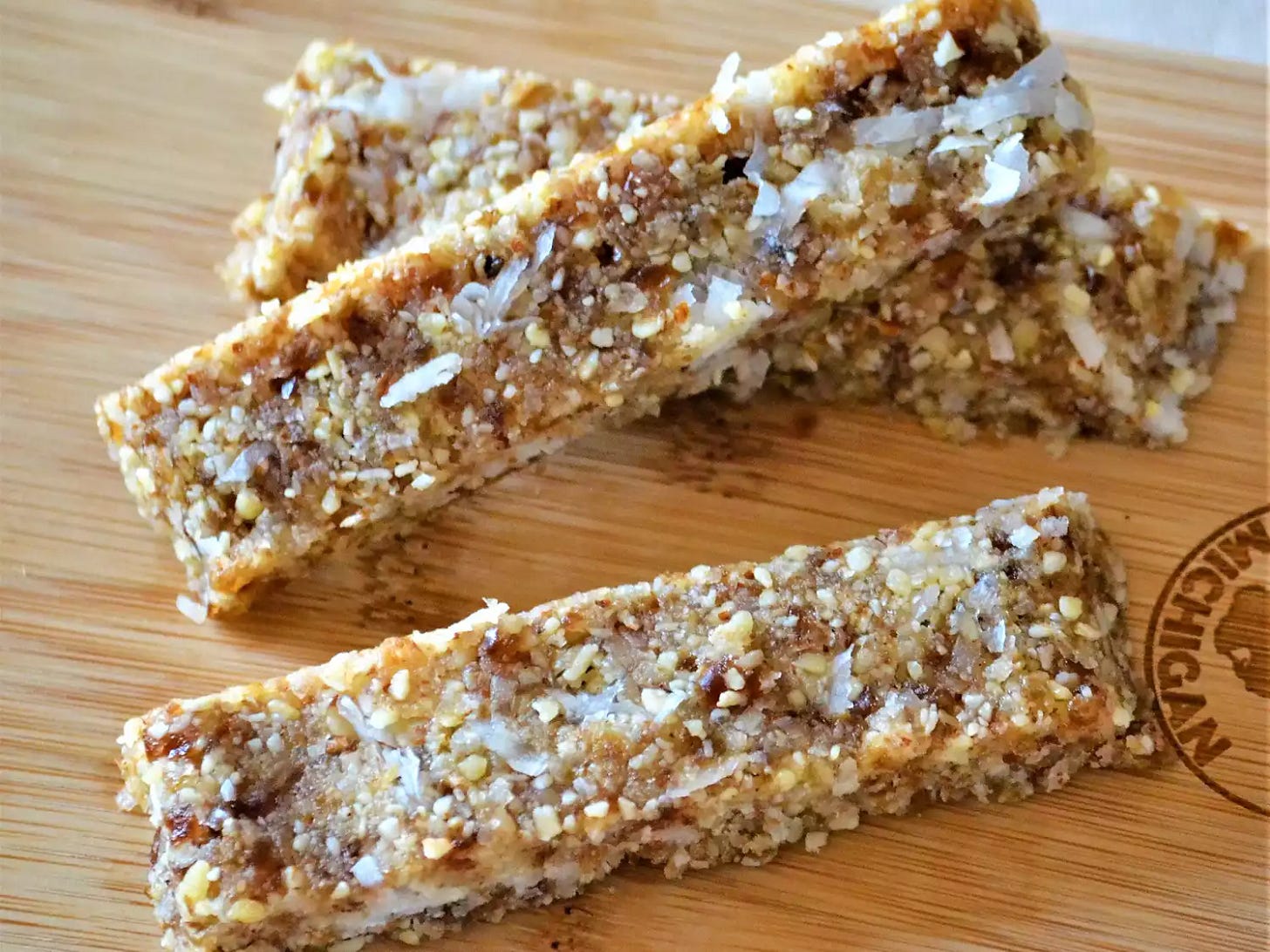 close up view of Coconut Date Bars on a wooden cutting board
