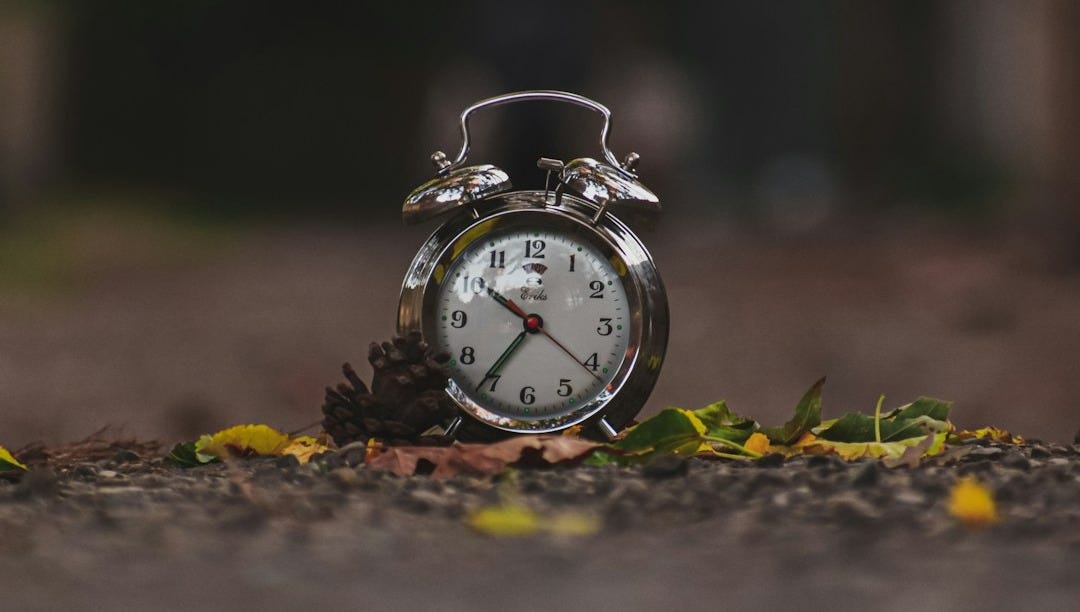 a small alarm clock sitting on the ground a small alarm clock sitting on the ground
