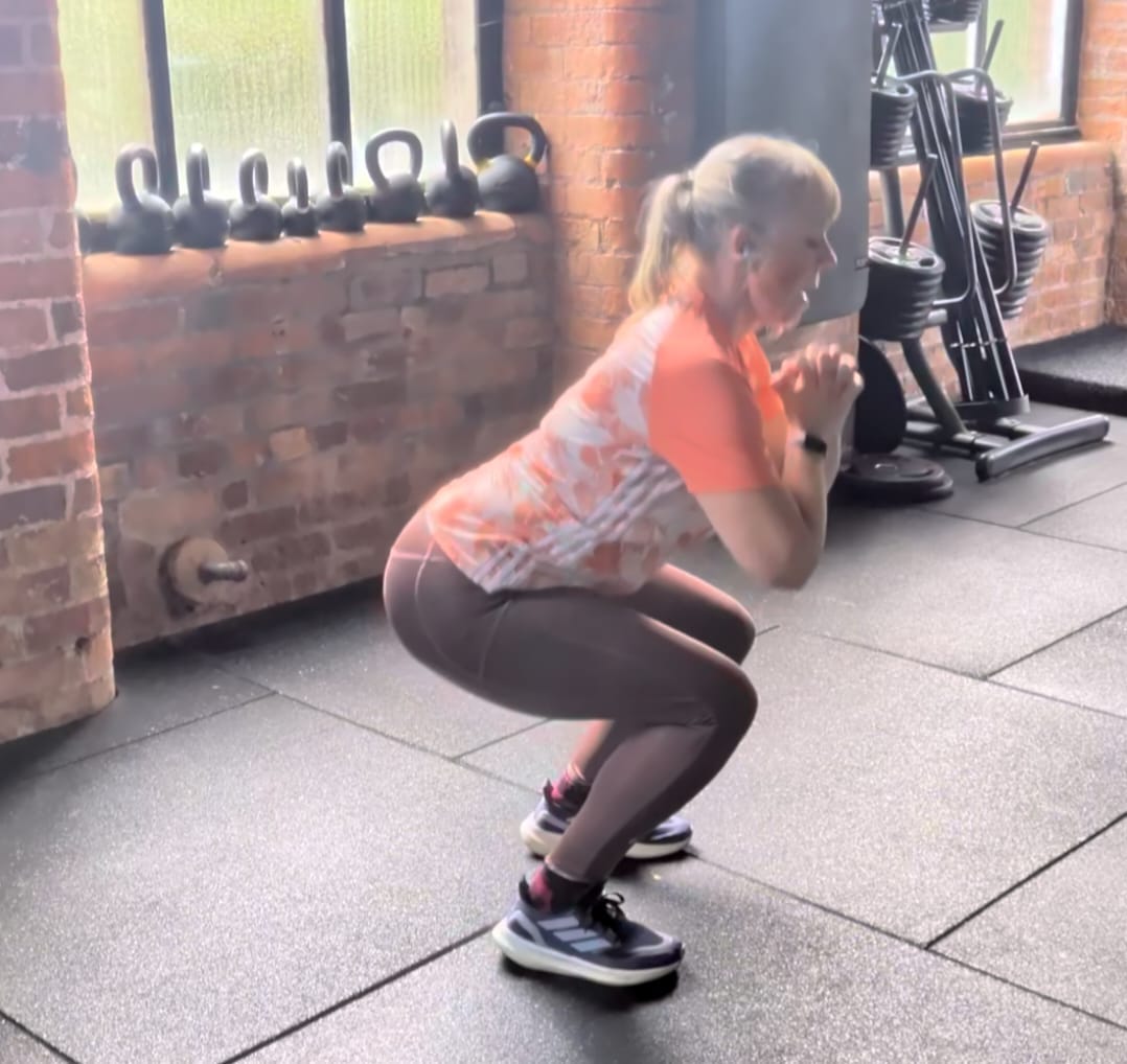 Image showing Andrea doing a bodyweight squat. Image showing Andrea doing a bodyweight squat.
