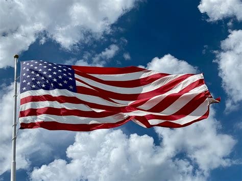 Photo of Cloudy Skies over American Flag · Free Stock Photo
