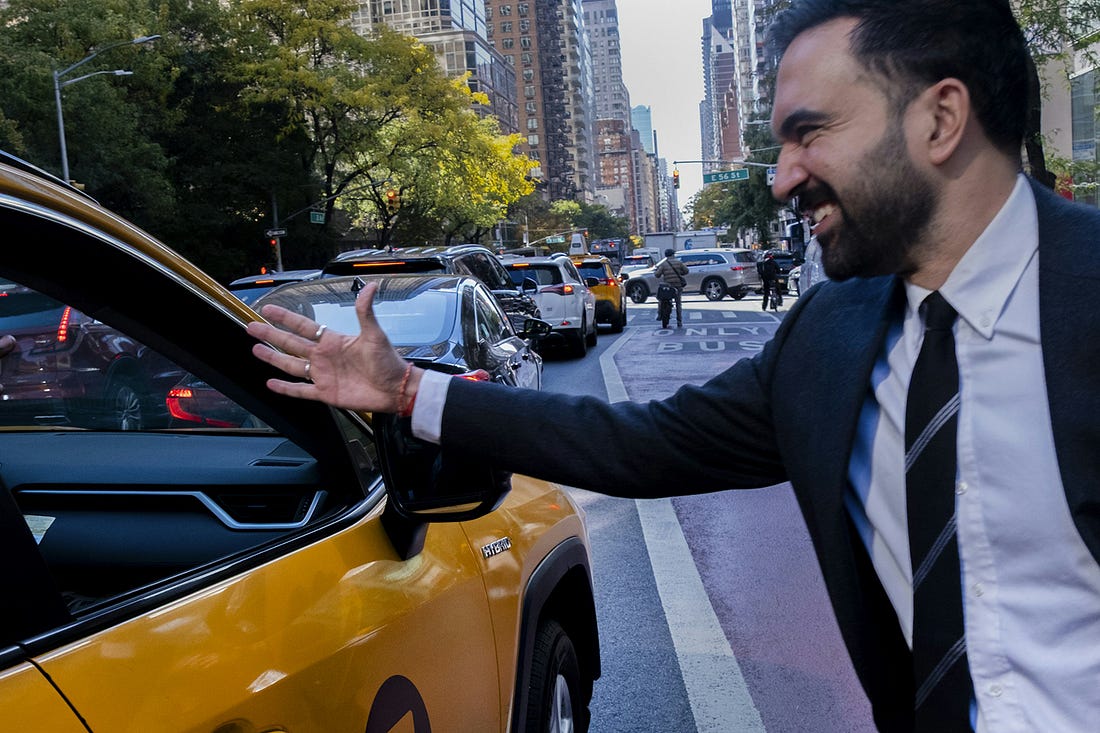 A photo of Zohran Mamdani shaking hands with a taxi driver 