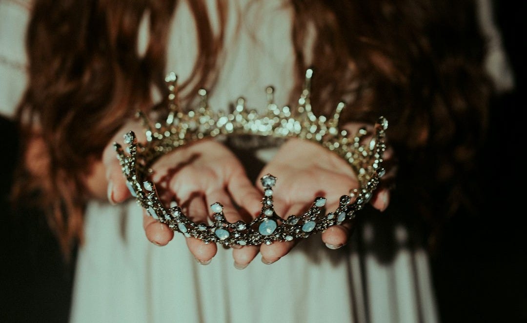 woman holding silver-colored crown