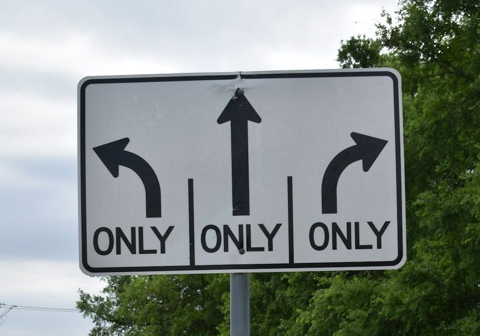 a white and black street sign on a pole