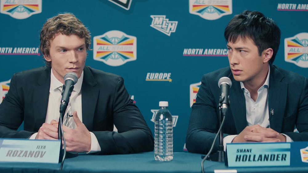 The two stars of Heated Rivalry in a scene from the show, at a press conference