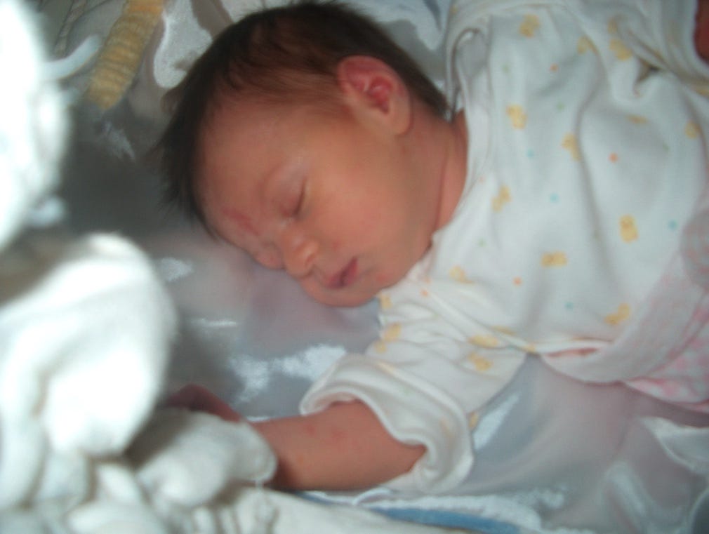 A baby sleeping in a crib

Description automatically generated