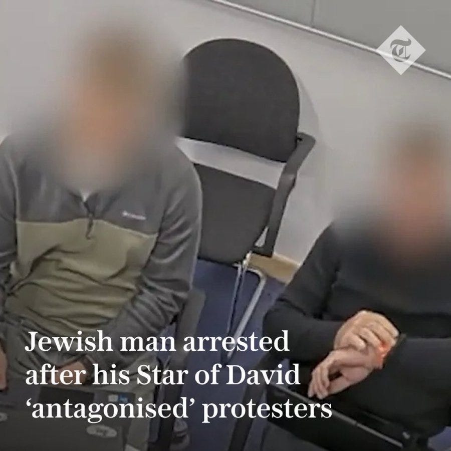 Blurred image of two individuals seated in office chairs one wearing a gray zip-up jacket with hands clasped the other in black clothing a Star of David necklace visible on one the setting includes a desk and wall with a clock faces are blurred to obscure identities caption text reads Jewish man arrested after his Star of David antagonised protesters