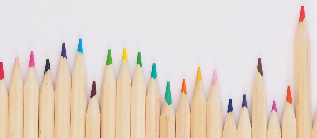 colored pencil lined up on top of white surface colored pencil lined up on top of white surface