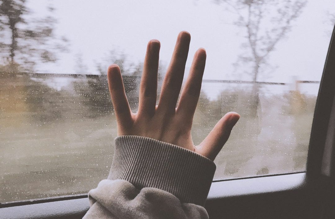 a person holding their hand out of a car window a person holding their hand out of a car window