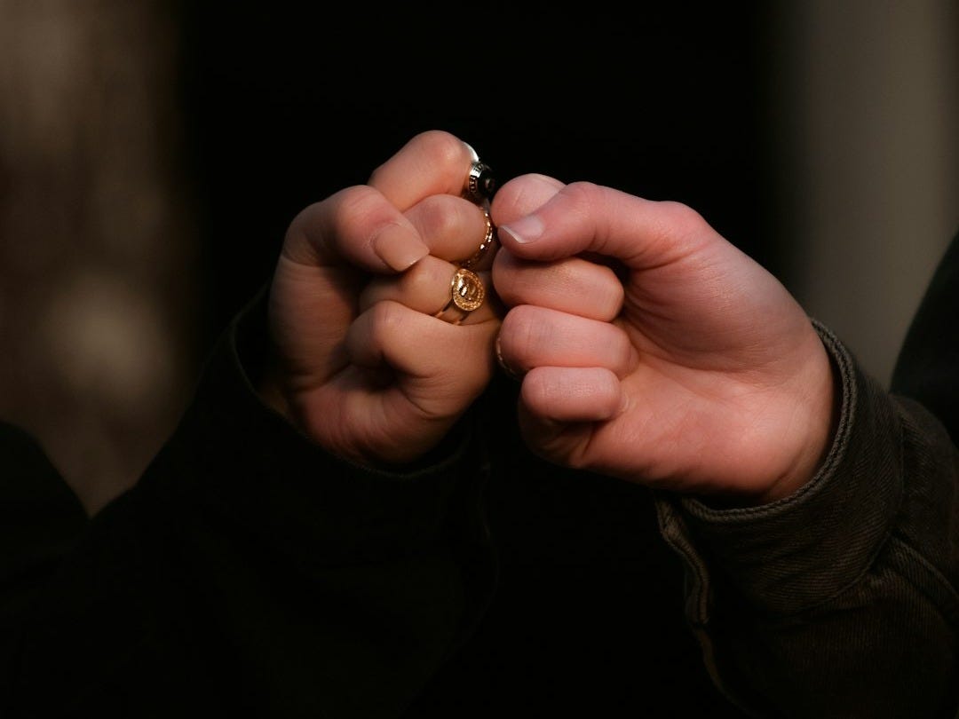 person holding gold ring in dark room person holding gold ring in dark room