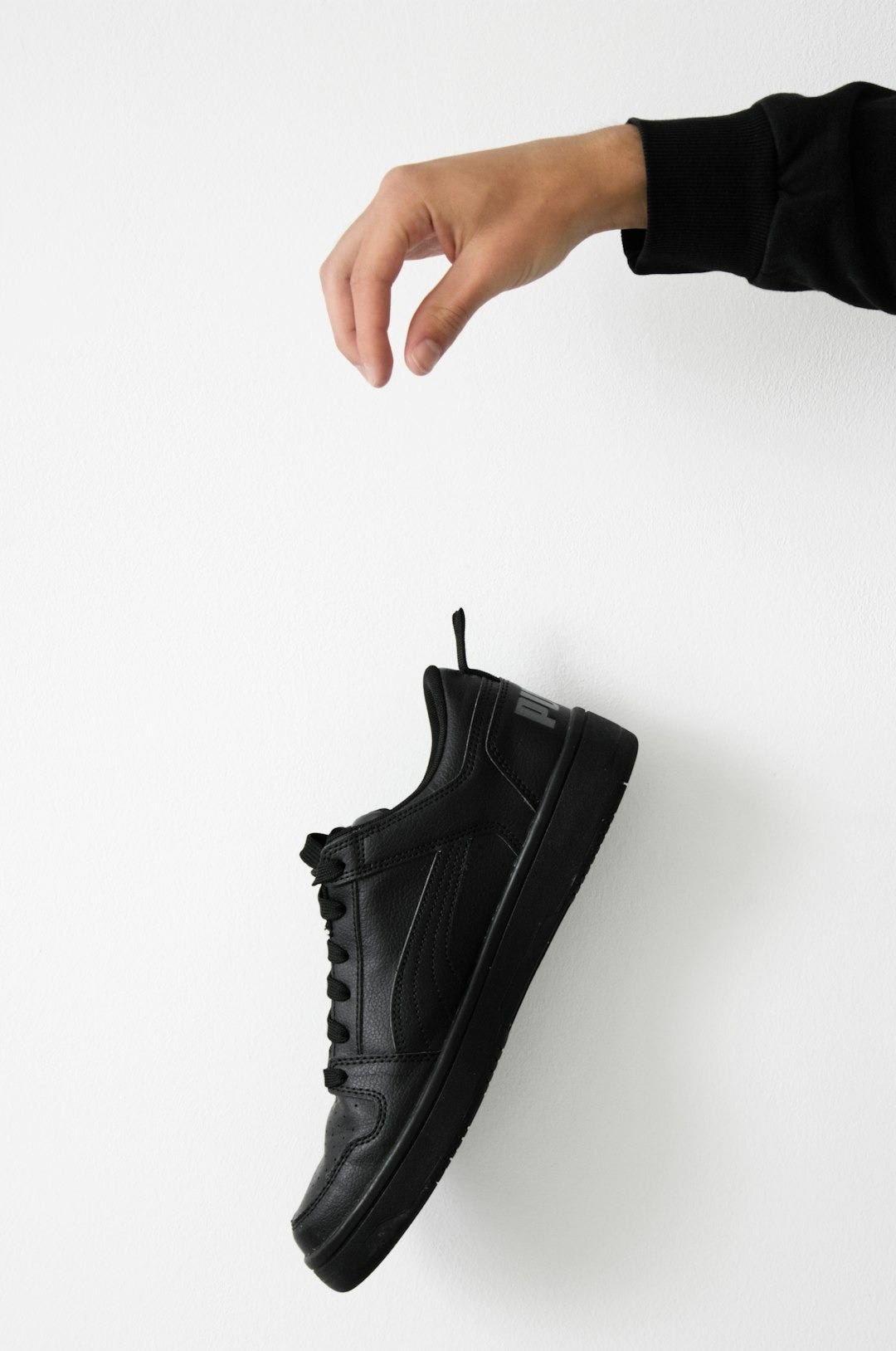 a pair of black shoes hanging on a wall a pair of black shoes hanging on a wall