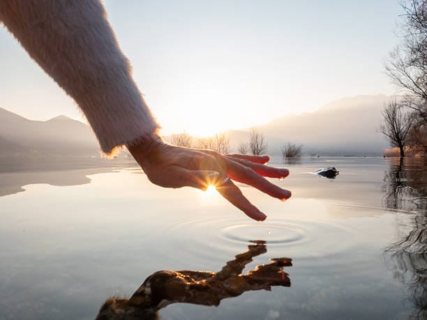 Detail Of Hand Touching Water Surface Of Lake At Sunset Stock Photo -  Download Image Now - iStock