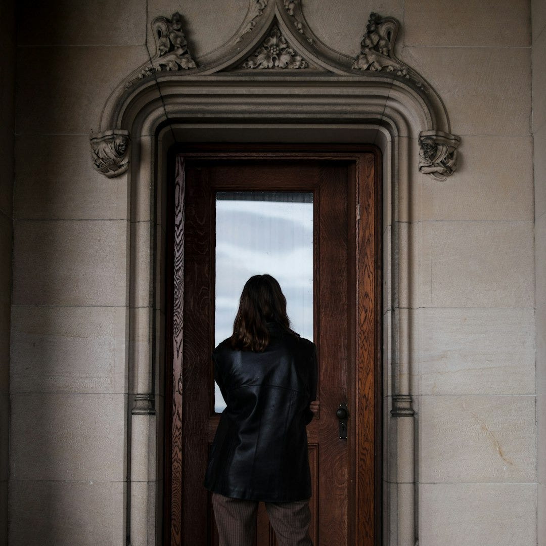 a man standing in front of a door a man standing in front of a door