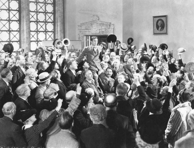 Shot from Mr. Deeds of the titular Mr. Deeds being hoisted onto the shoulders of those celebrating his court victory Shot from Mr. Deeds of the titular Mr. Deeds being hoisted onto the shoulders of those celebrating his court victory