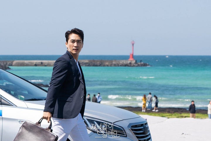 A man and a woman looking melancholy on the beach in Jeju Island
