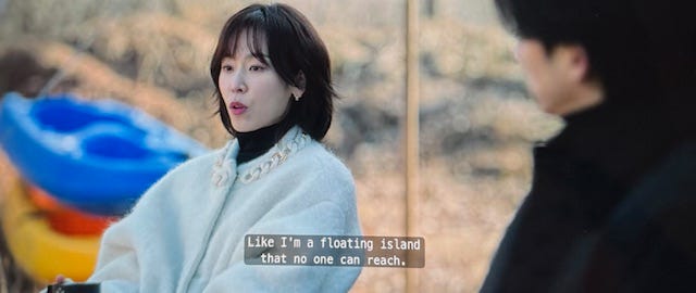 Noh In-Ji talks about kayaking outside of the lake house in a white fuzzy sweater at the lake house in episode 6 of The Trunk on Netflix