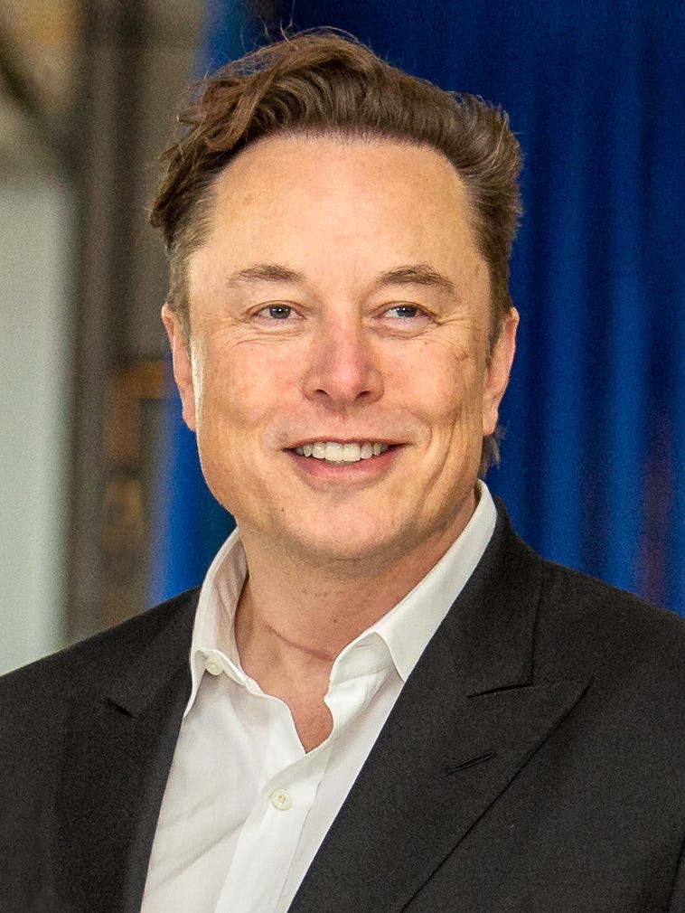 elon musk head shot; he's in a jacket and open collar shirt