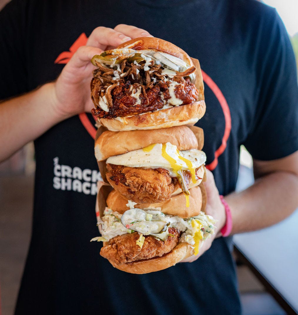 Imagine of a person holding three sandwiches on top of each other