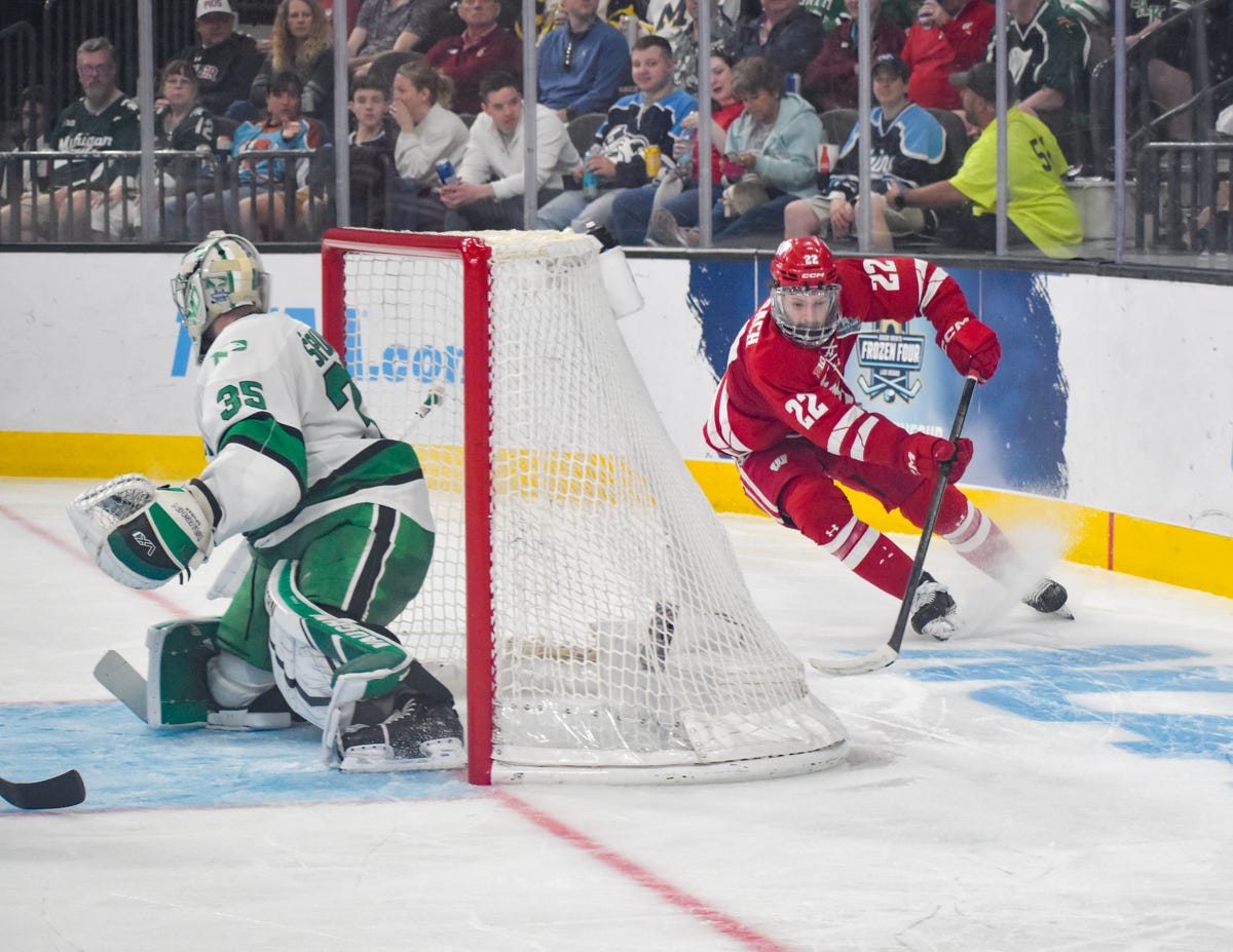 Jack Horbach attempts to put a puck on his backhand while the Fighting Hawks goaltender is seen trying to keep track of the puck