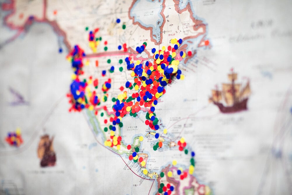 Detail of the map at Reissue Cafe where visitors have left their mark of their home town.