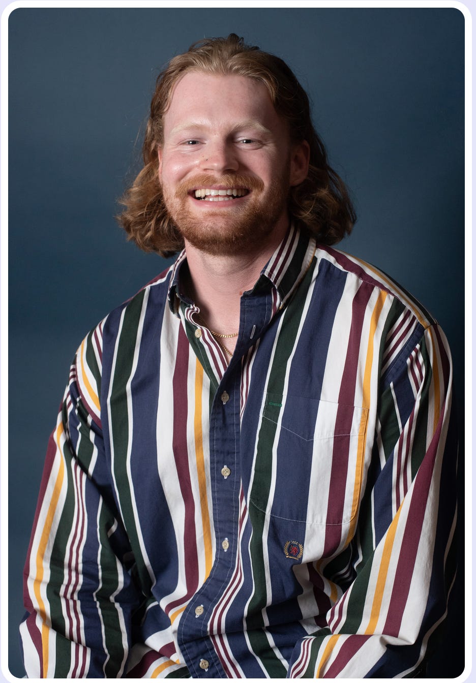 A portrait of a smiling man in a striped button-down shirt. A portrait of a smiling man in a striped button-down shirt.