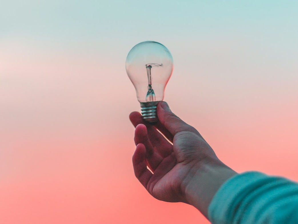 person holding light bulb person holding light bulb