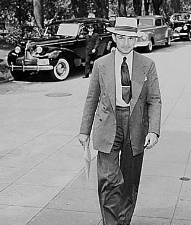 A person in a suit and tie walking on a sidewalk

Description automatically generated with medium confidence