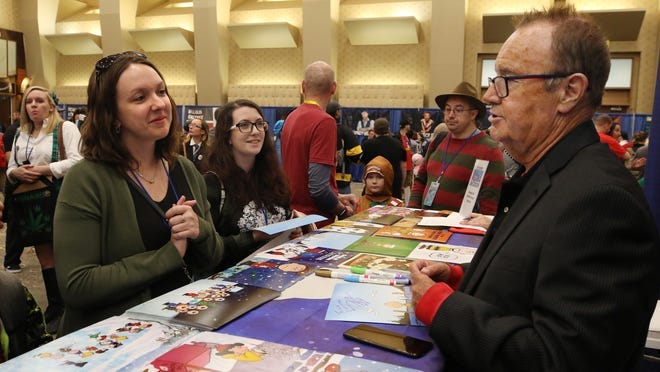 Peter Robbins, the voice of cartoon character Charlie Brown, talks to Michelle Kroc of East Haddam, Conn., Saturday at Comic Con, after he signed an autograph for her.