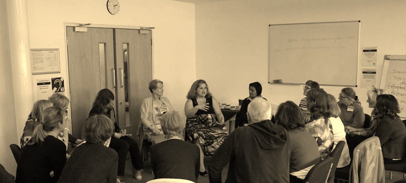 Jamie sitting in a circle talking to a group of about 10 people