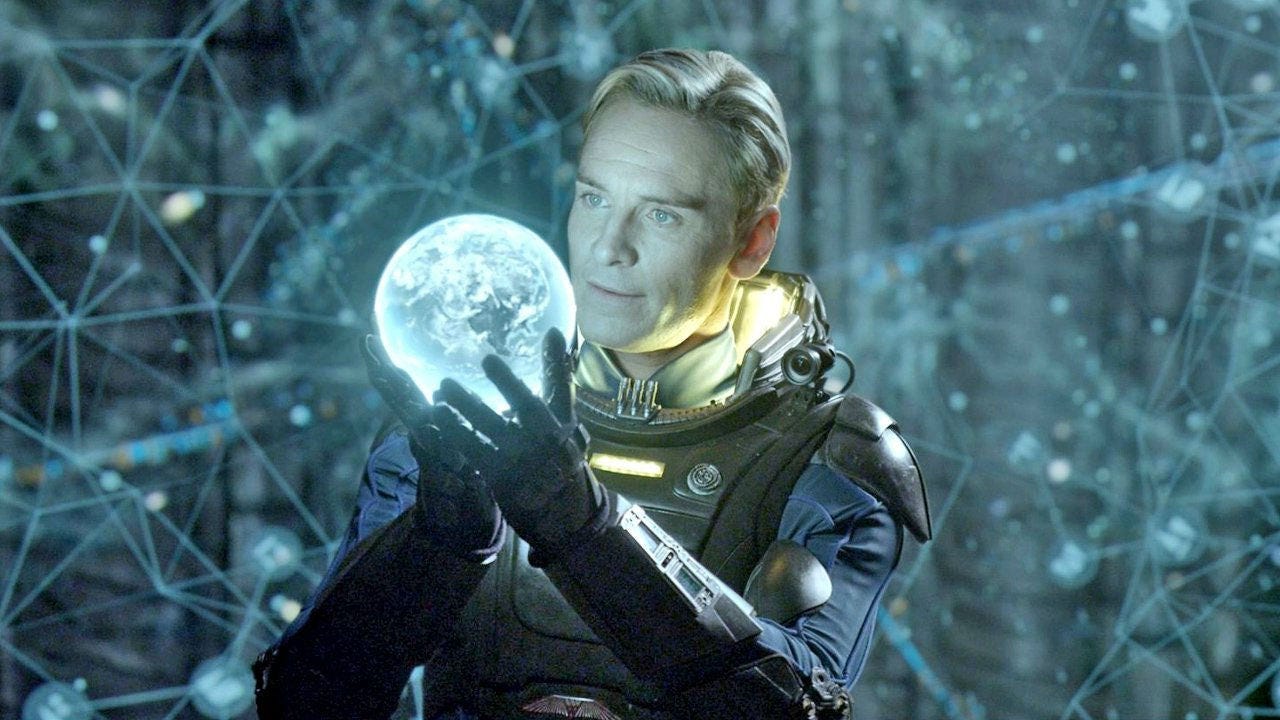 michael fassbender med en holografisk globus