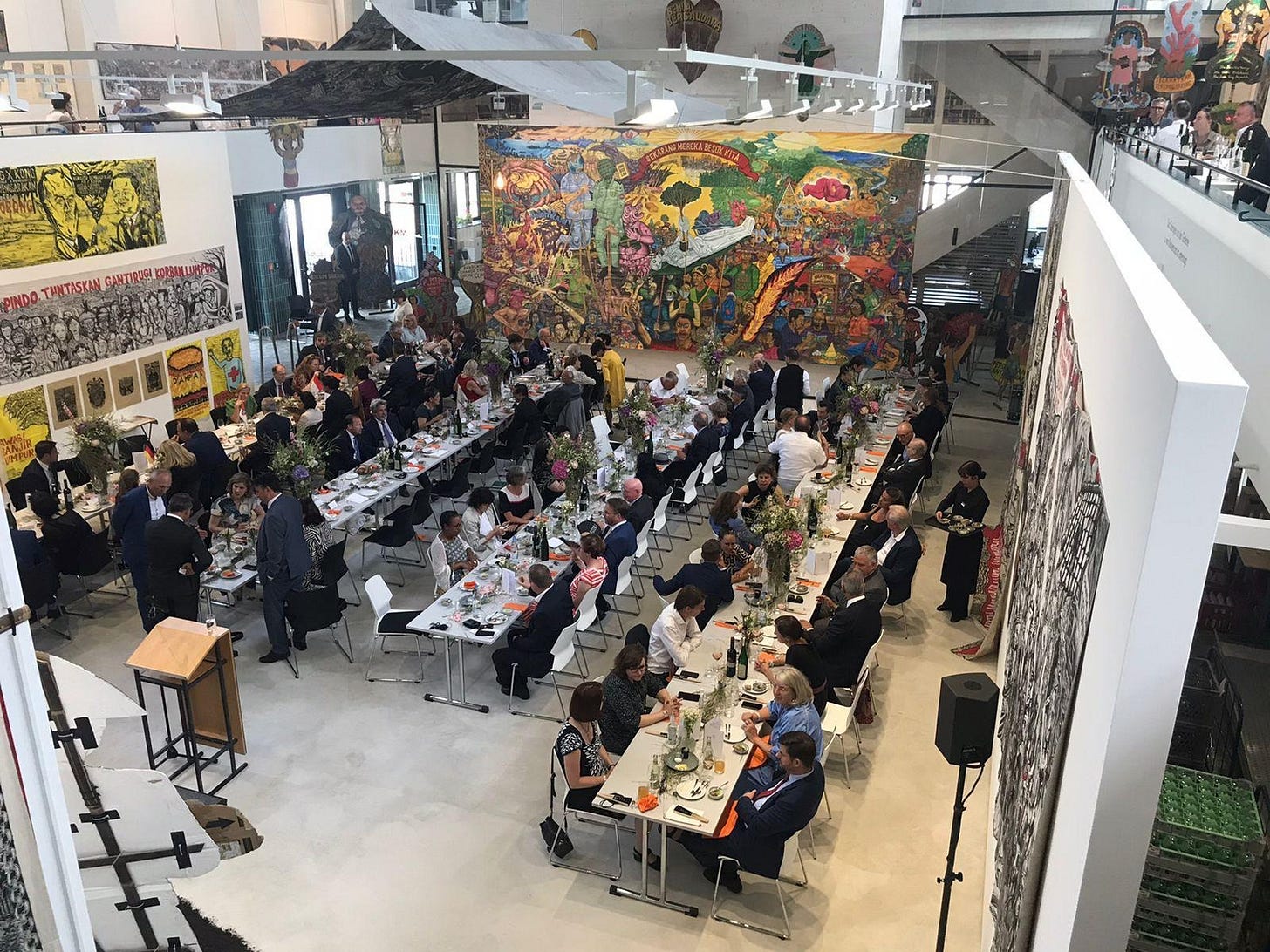 A group of people sitting at tables in a room with a large mural
Description automatically generated A group of people sitting at tables in a room with a large mural
Description automatically generated