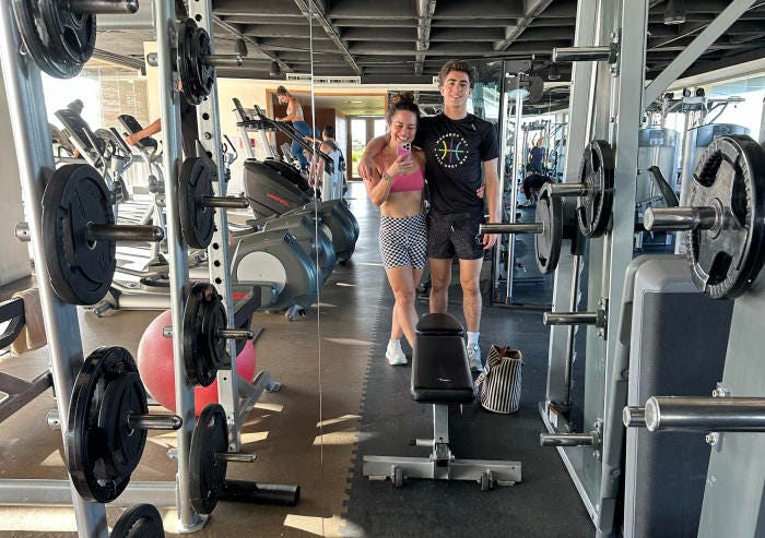 Woman and man posing in a gym.