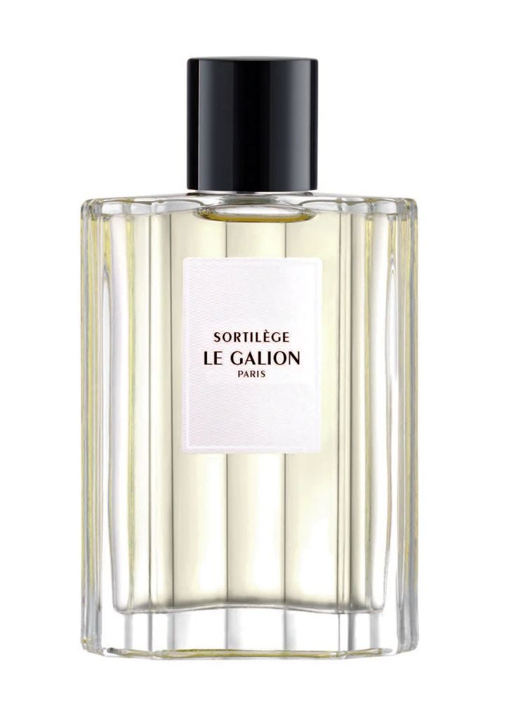A clear glass perfume bottle with a black cap, featuring a simple white label with the text 'Sortilège Le Galion Paris'.