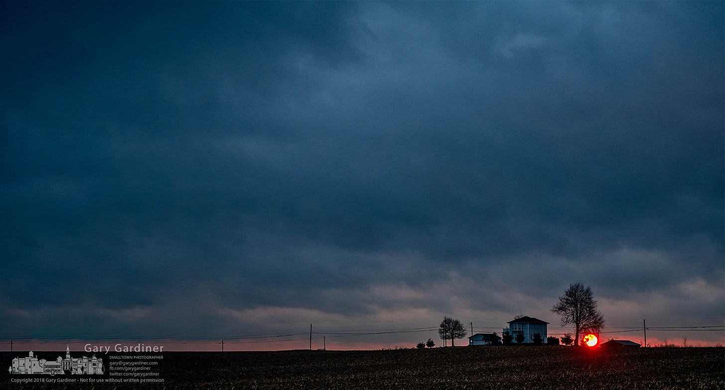 The sun breaks through a sliver of clear sky at the edge of rainy cloud cover just as it settles into the sunset behind an old farmhouse near Johnstown, Ohio. My Final Photo for Nov. 24, 2018. The sun breaks through a sliver of clear sky at the edge of rainy cloud cover just as it settles into the sunset behind an old farmhouse near Johnstown, Ohio. My Final Photo for Nov. 24, 2018.