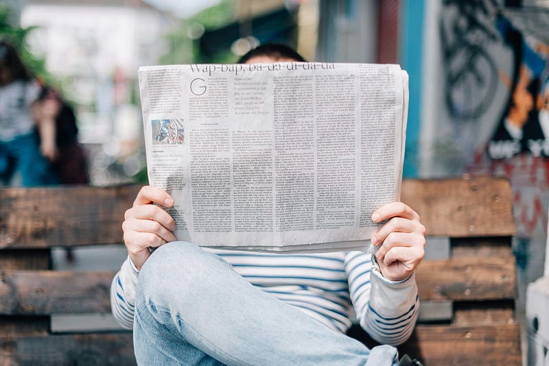 A person sitting and reading a newspaper