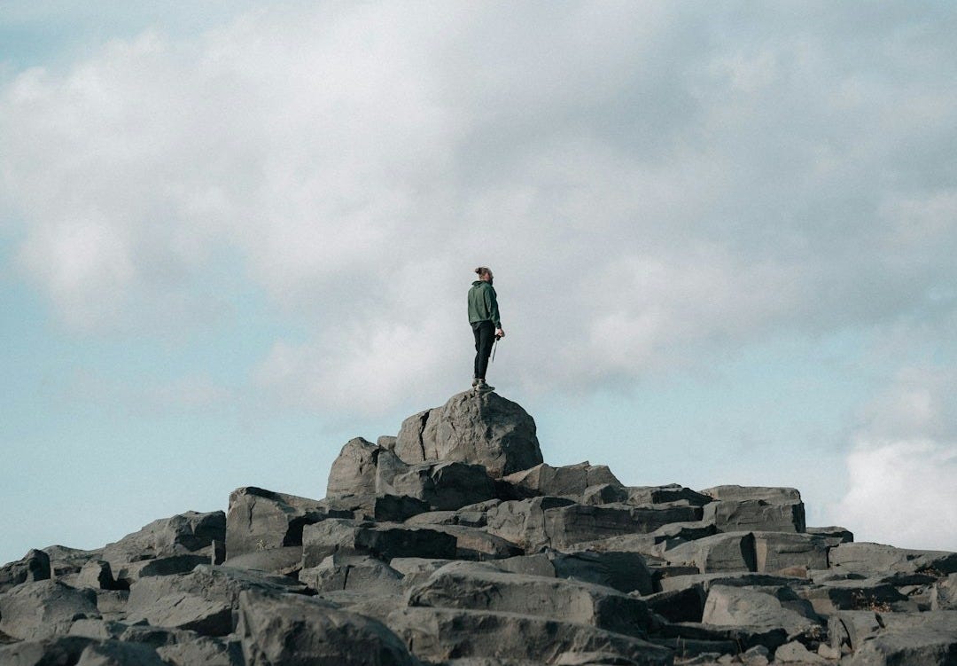 a man standing on top of a large pile of rocks