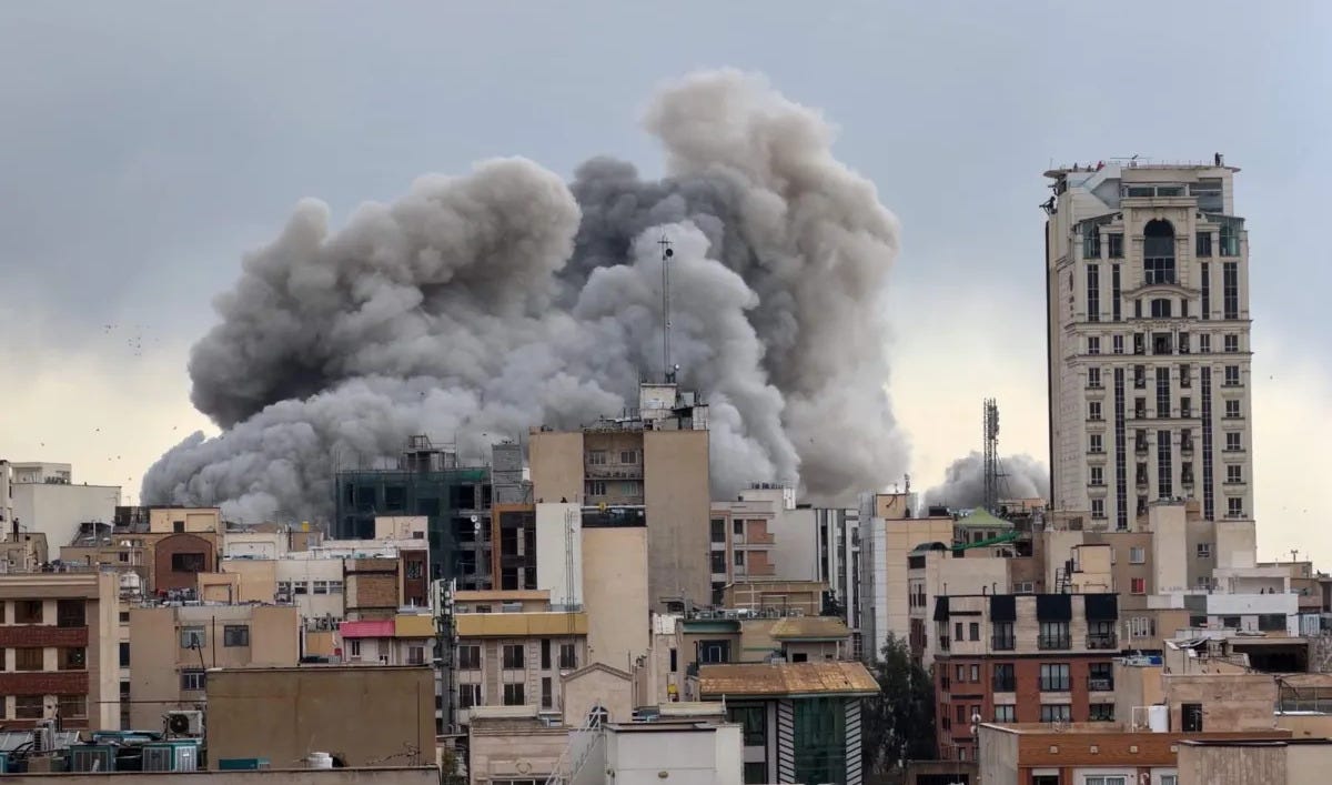 A huge billowing gray smoke cloud rises over the near skyline of Tehran by day. A huge billowing gray smoke cloud rises over the near skyline of Tehran by day.