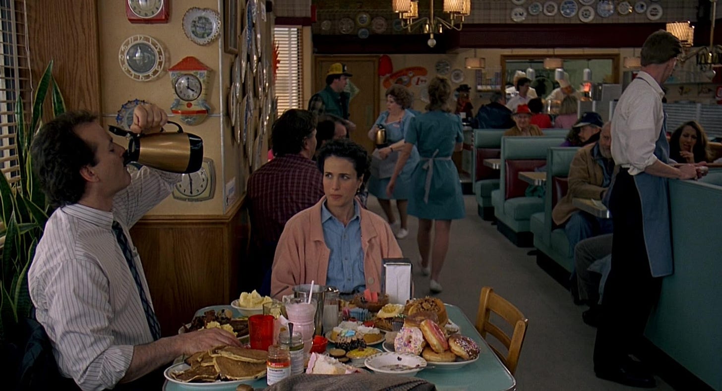 Phil and Rita are sat at a diner table covered in seemingly everything on the menu.