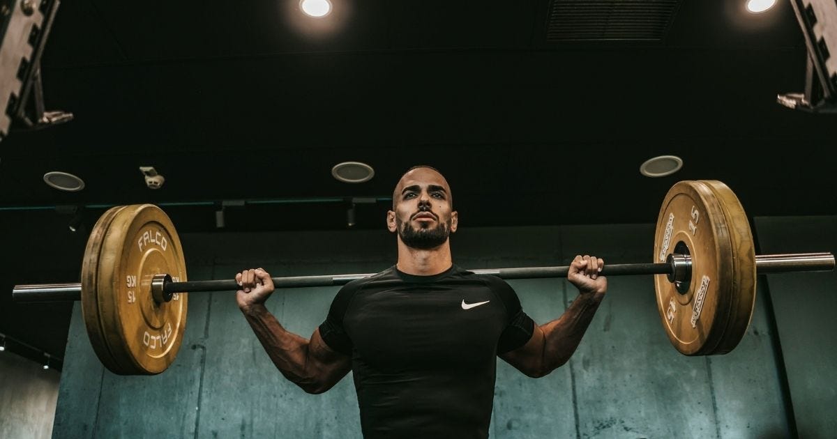 Man with a loaded barbell sitting on his back Man with a loaded barbell sitting on his back