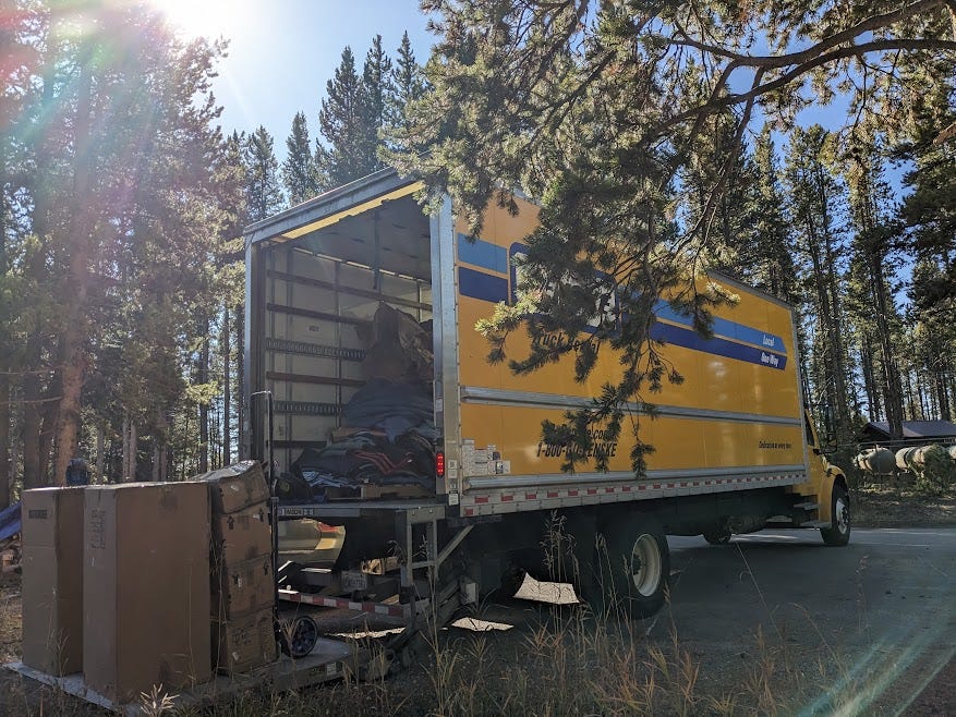 a yellow moving truck pulls up