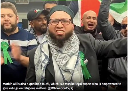 A person with a beard and a scarf and a green ribbon

Description automatically generated