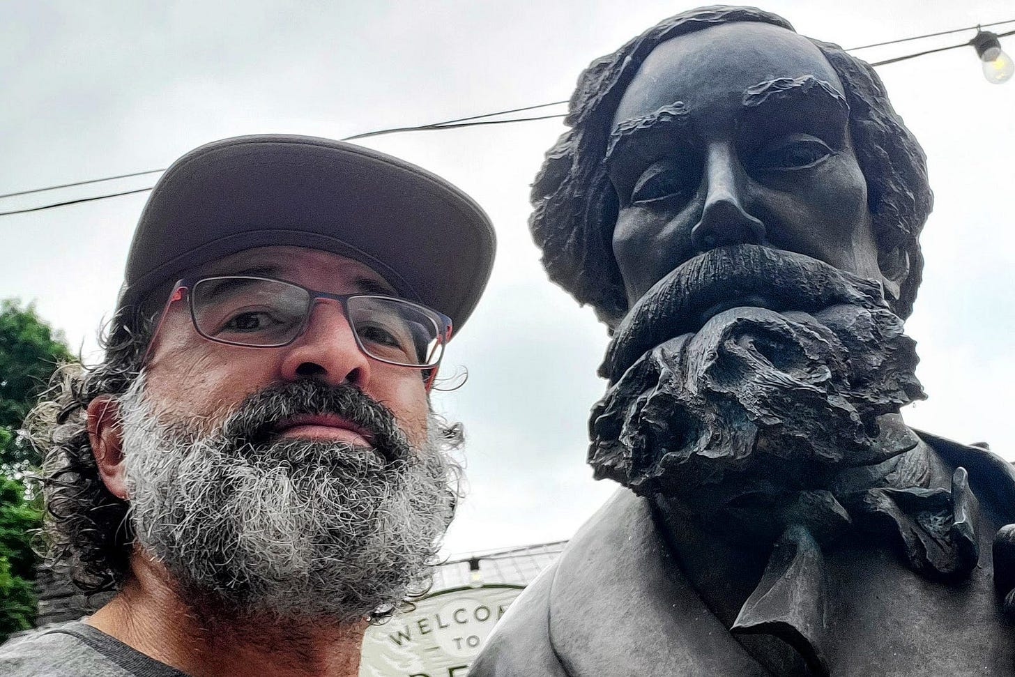 Selfie of the author comparing his salt-and-pepper beard to the elaborate bronze beard on a George Dickel statue.